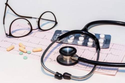 Stethoscope, glasses, pills, and chart heart