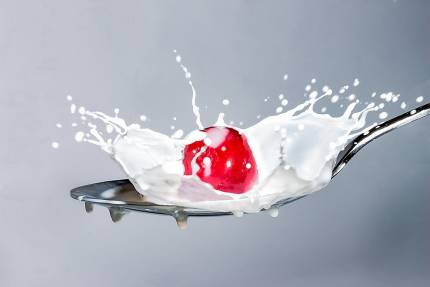 Spoon with milk and cherries